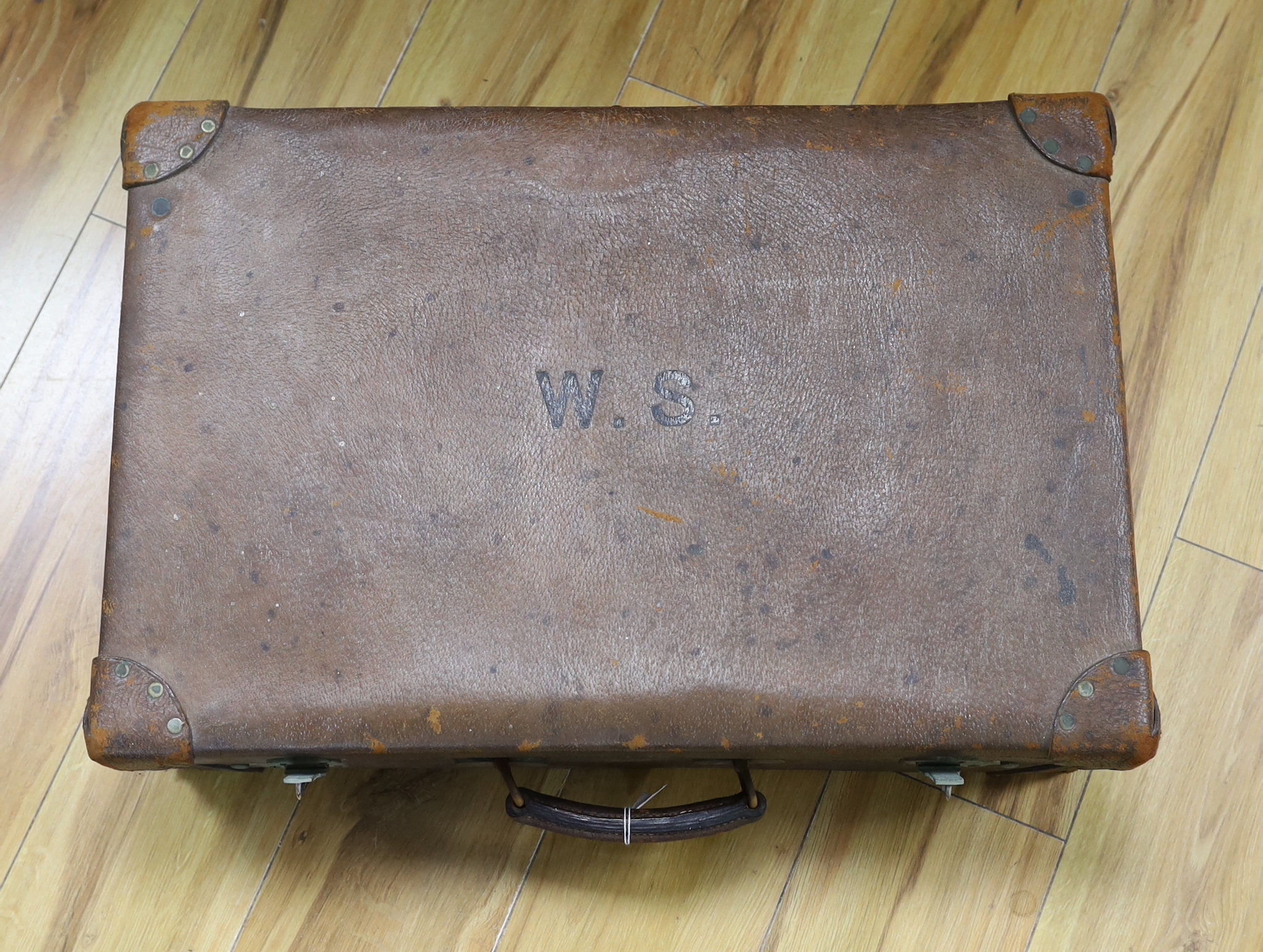 An Edwardian leather travelling toilet case, containing eleven silver mounted toilet jars etc. including a mounted glass hip flask and easel mirror, Drew & Sons, London, 1905, case width 62.5cm.